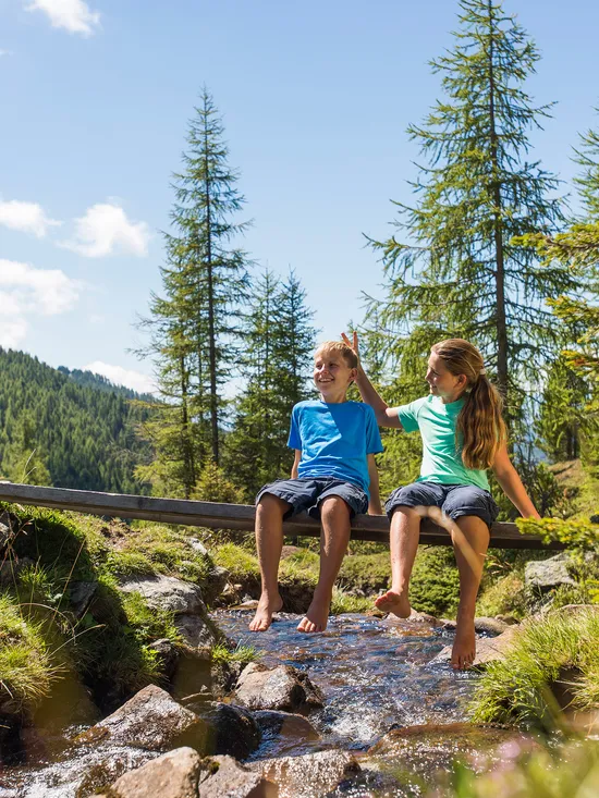 Kinder wandern an einem Bach in den Nockbergen bei Bad Kleinkirchheim